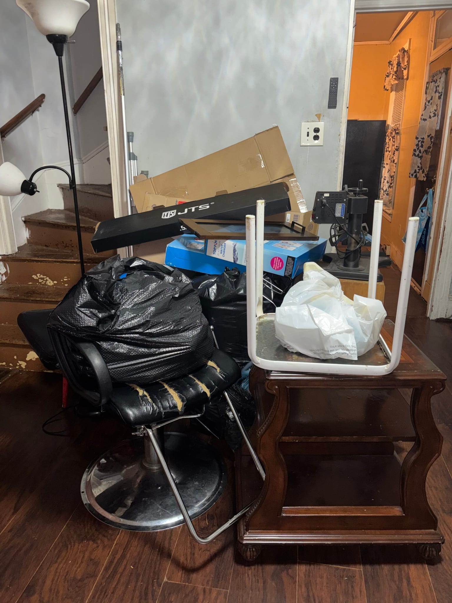 Before: living room cluttered with boxes, couch and old TV